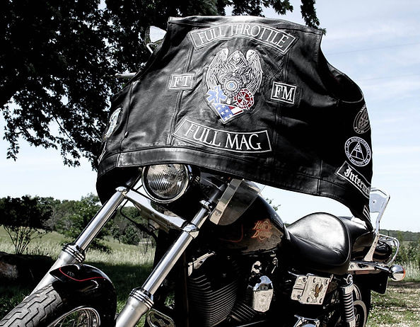 FTFM vest draped over a Harley parked under a tree